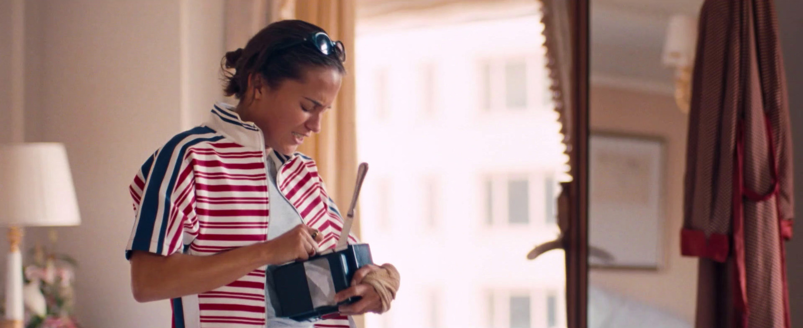 a woman in a red and white striped shirt holding a camera