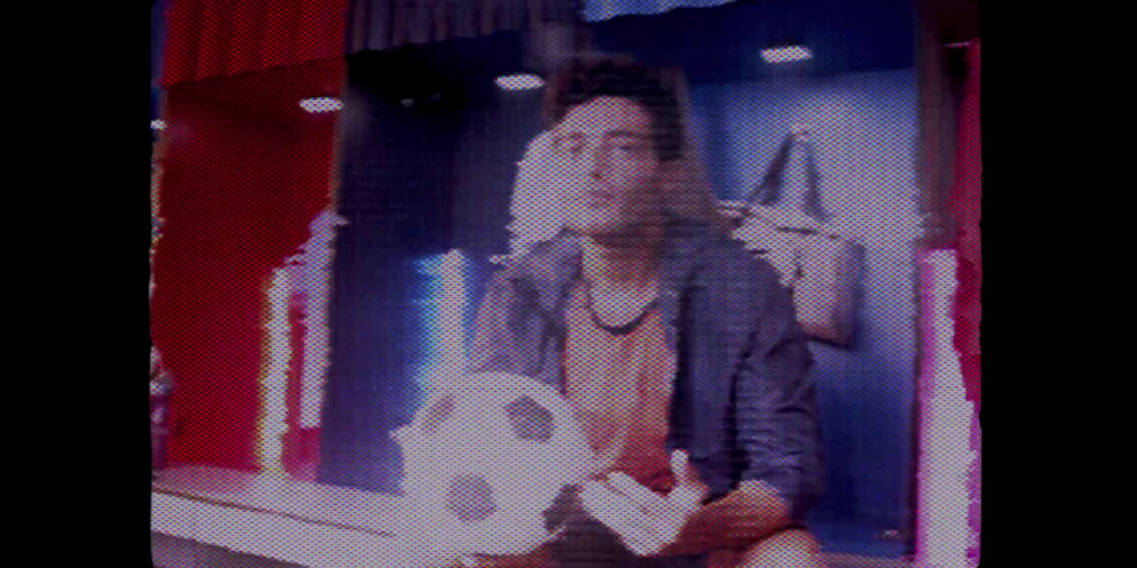 a man holding a soccer ball in front of a window