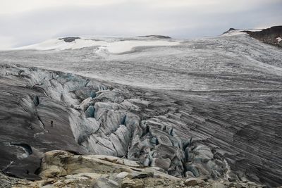 a man standing on top of a mountain next to a glacier