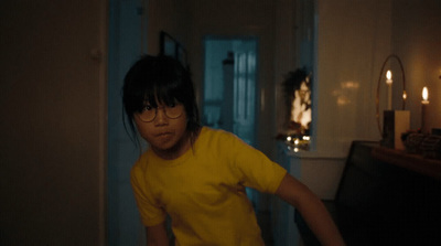 a woman in a yellow shirt standing in a room