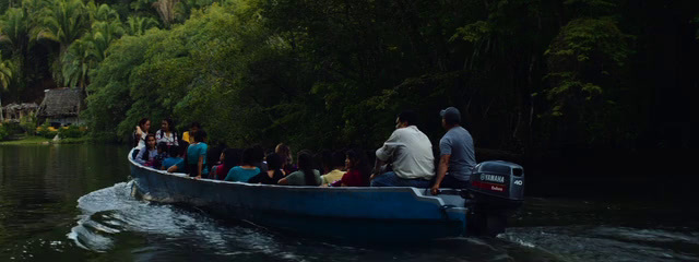 a group of people riding on the back of a blue boat