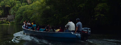 a group of people riding on the back of a blue boat