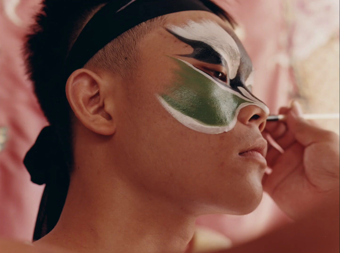 a woman with a green and white face paint