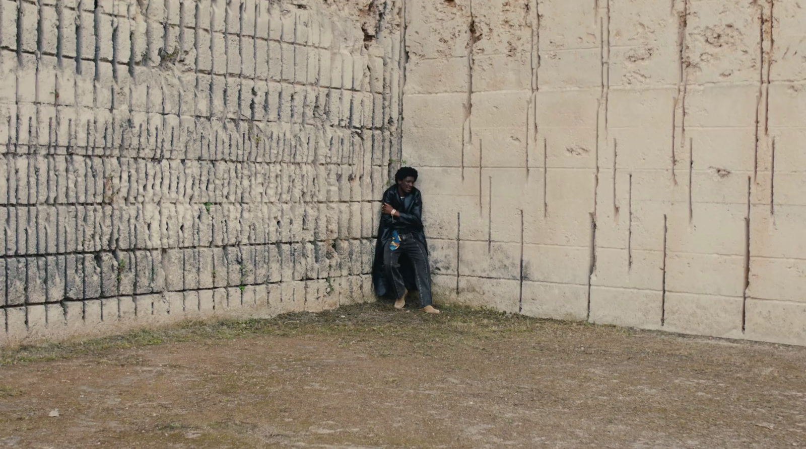 a person standing in front of a brick wall