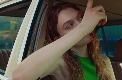 a woman with red hair sitting in a car