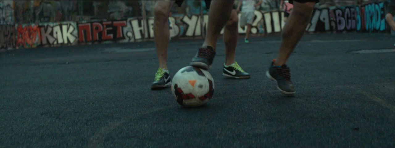 a man is kicking a soccer ball in the street