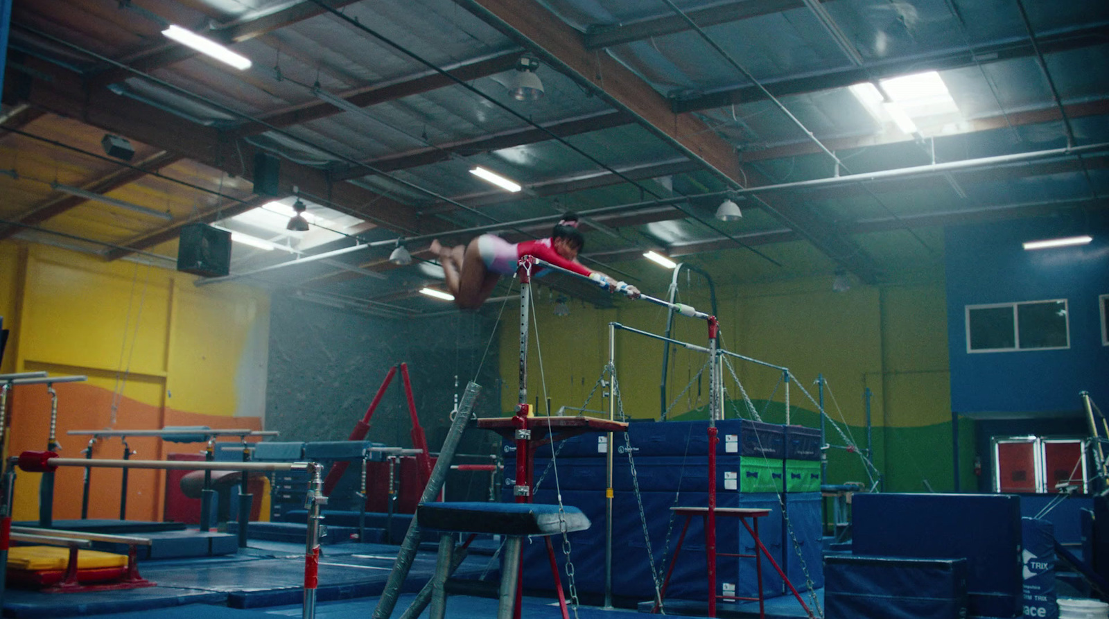 a person on a high bar in a gym