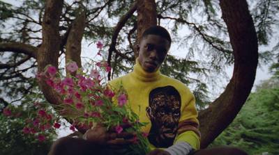 a man in a yellow shirt holding a bouquet of flowers