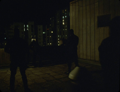 a group of people standing on top of a roof at night