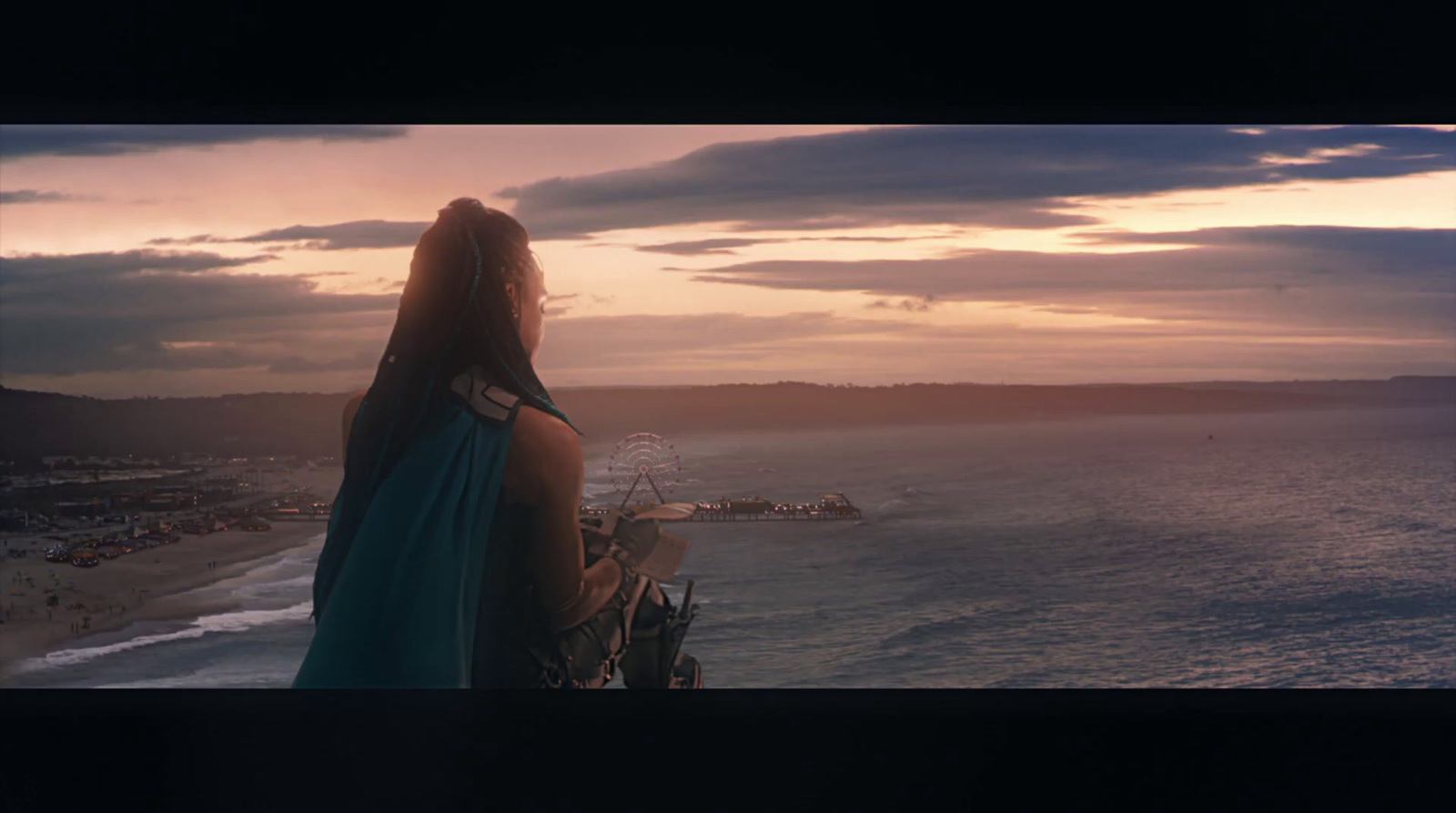 a woman looking out over the ocean at sunset