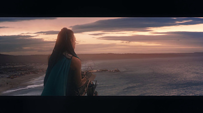 a woman looking out over the ocean at sunset