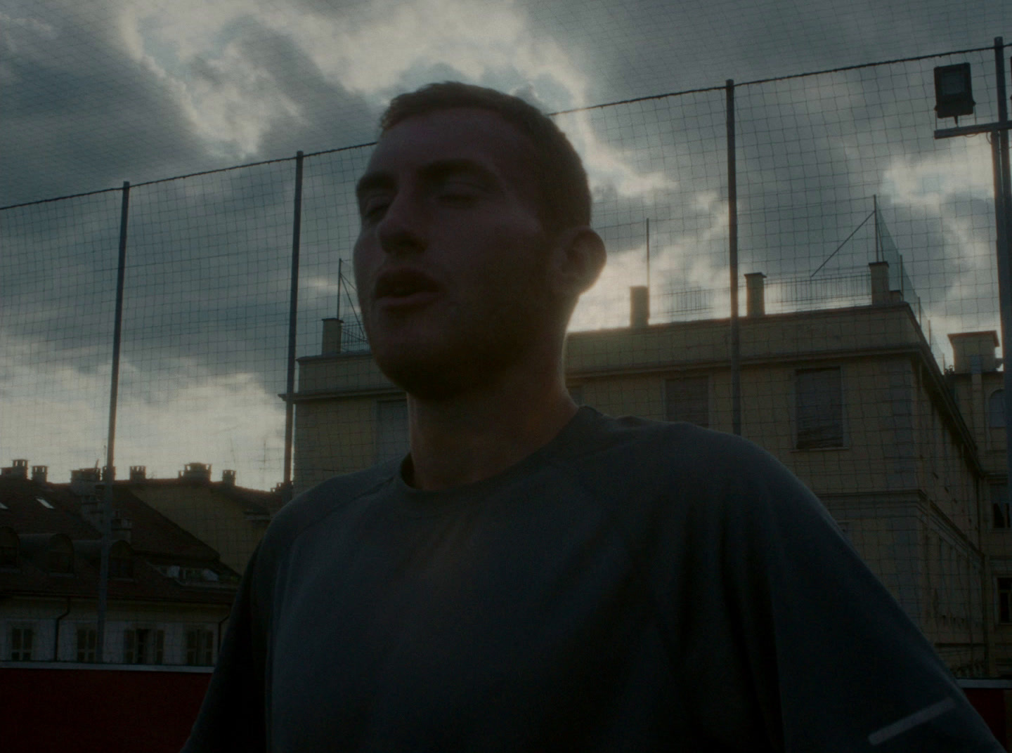 a man is standing in front of a fence