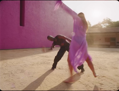 a man and a woman dancing in the sand