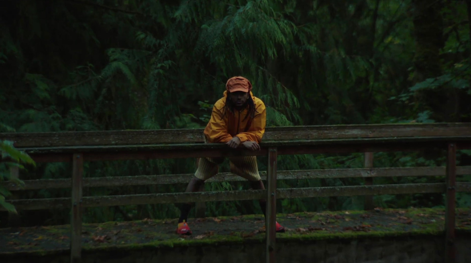 a man sitting on a wooden bench in the rain