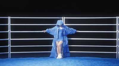 a woman in a raincoat standing in front of a fence