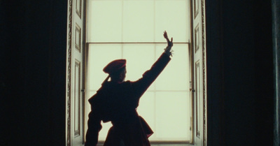 a woman standing in front of a window with her arms in the air