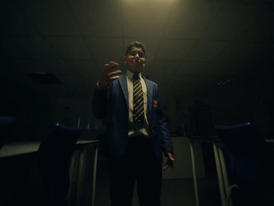 a man in a suit and tie standing in a dark room