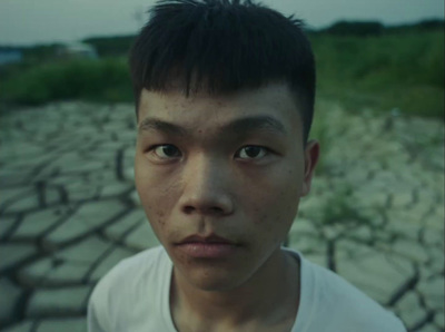 a man standing in front of a dirt field