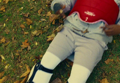 a little boy laying on the ground with a red shirt on