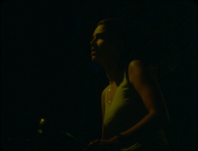 a woman standing in the dark with her eyes closed