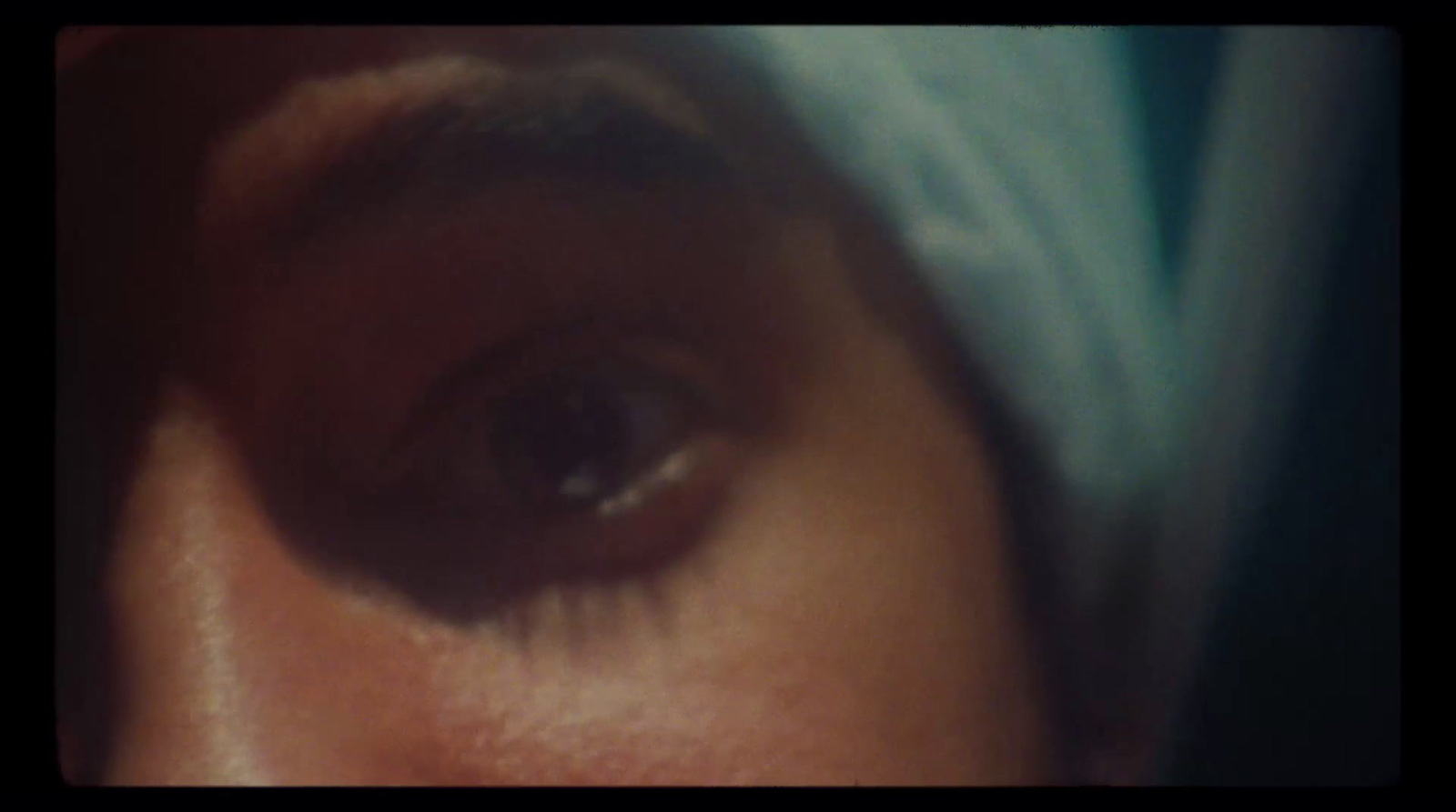 a close up of a woman's eye with a towel on her head