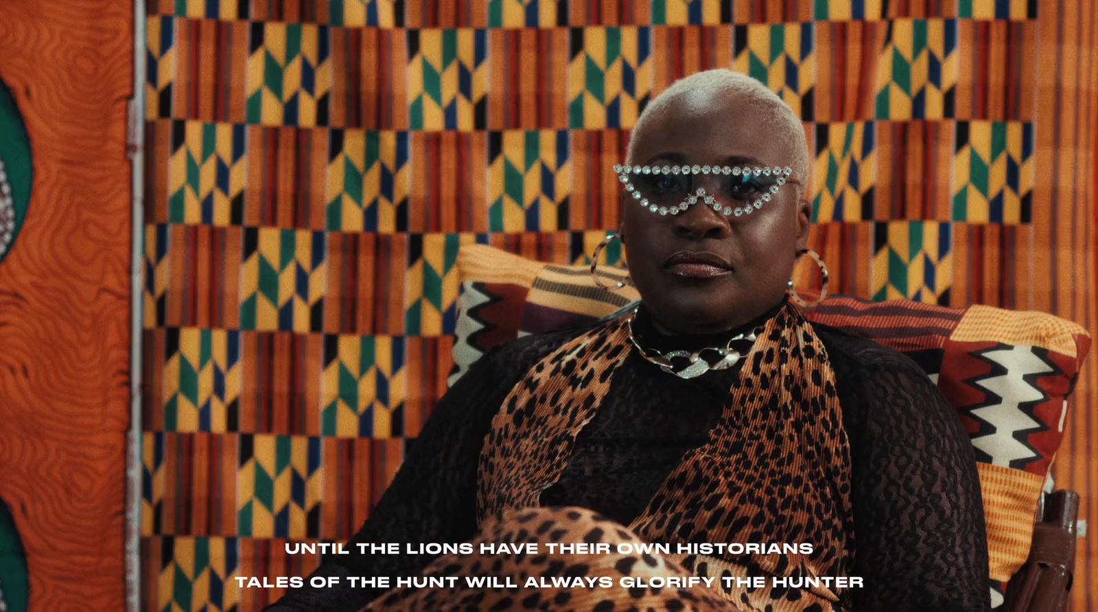 a woman sitting in a chair with a leopard print scarf around her neck