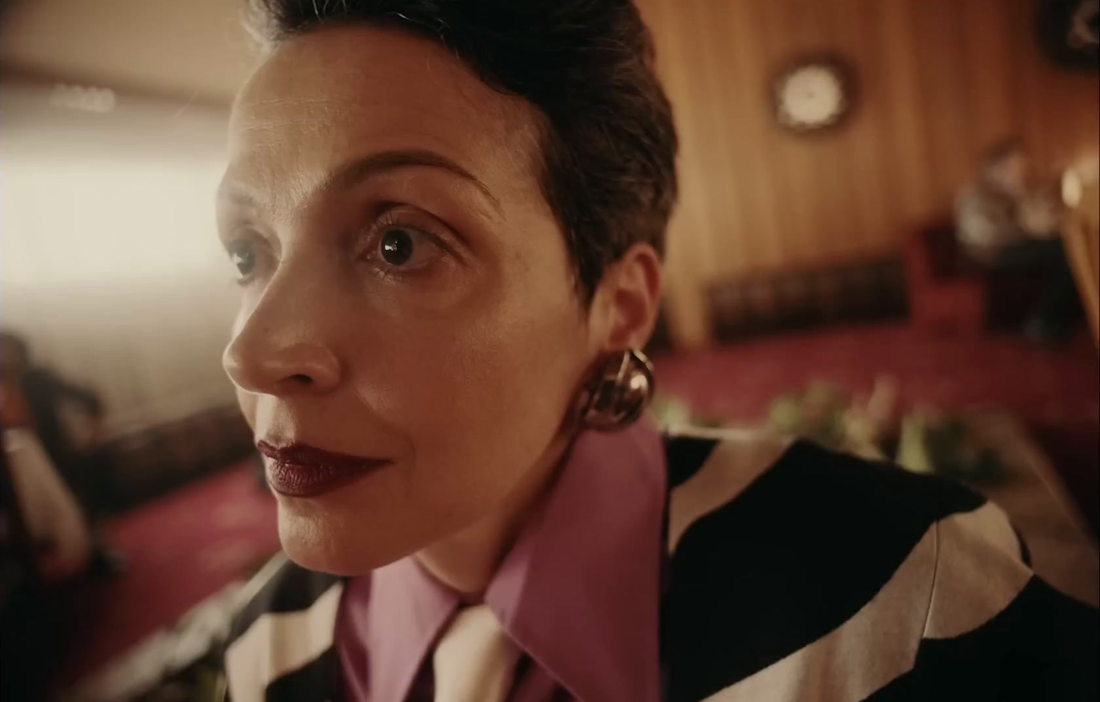 a woman in a black and white striped shirt and earrings