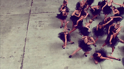 a group of dancers are dancing on a sidewalk