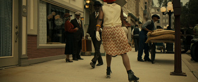 a woman walking down a street with a red umbrella