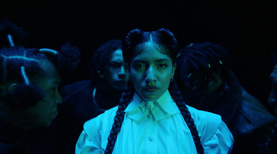 a woman with braids standing in front of a group of people