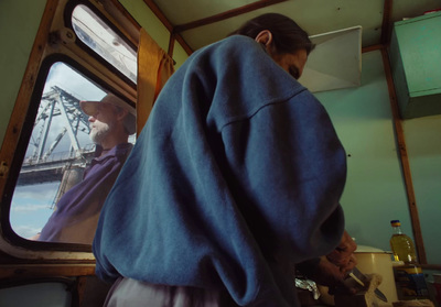 a man in a blue jacket looking out a window