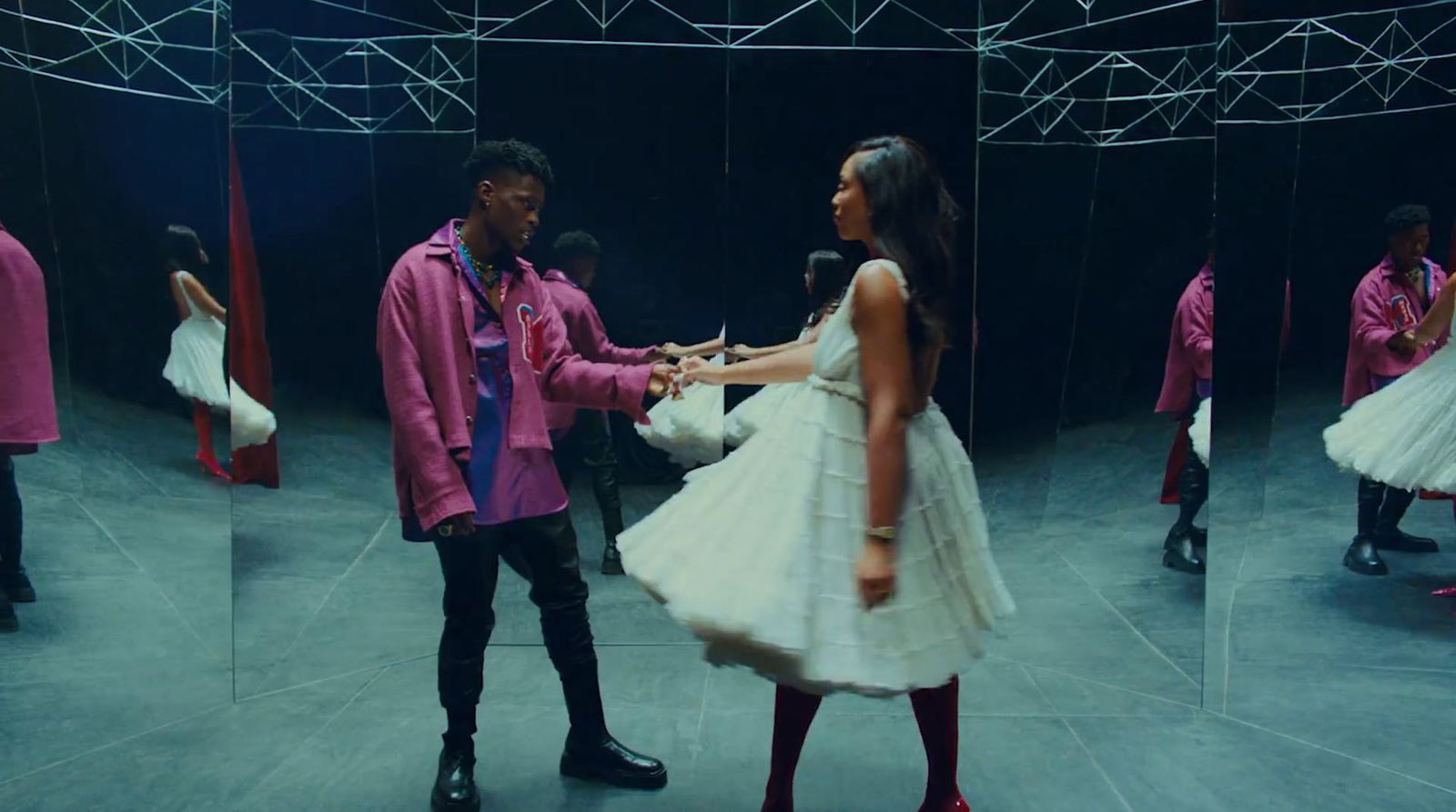 a man and a woman standing in front of a mirror