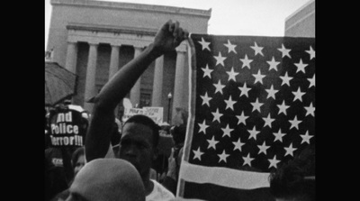 a black and white photo of a man holding an american flag