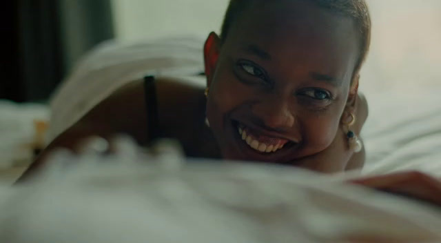 a woman laying on top of a bed with a smile on her face