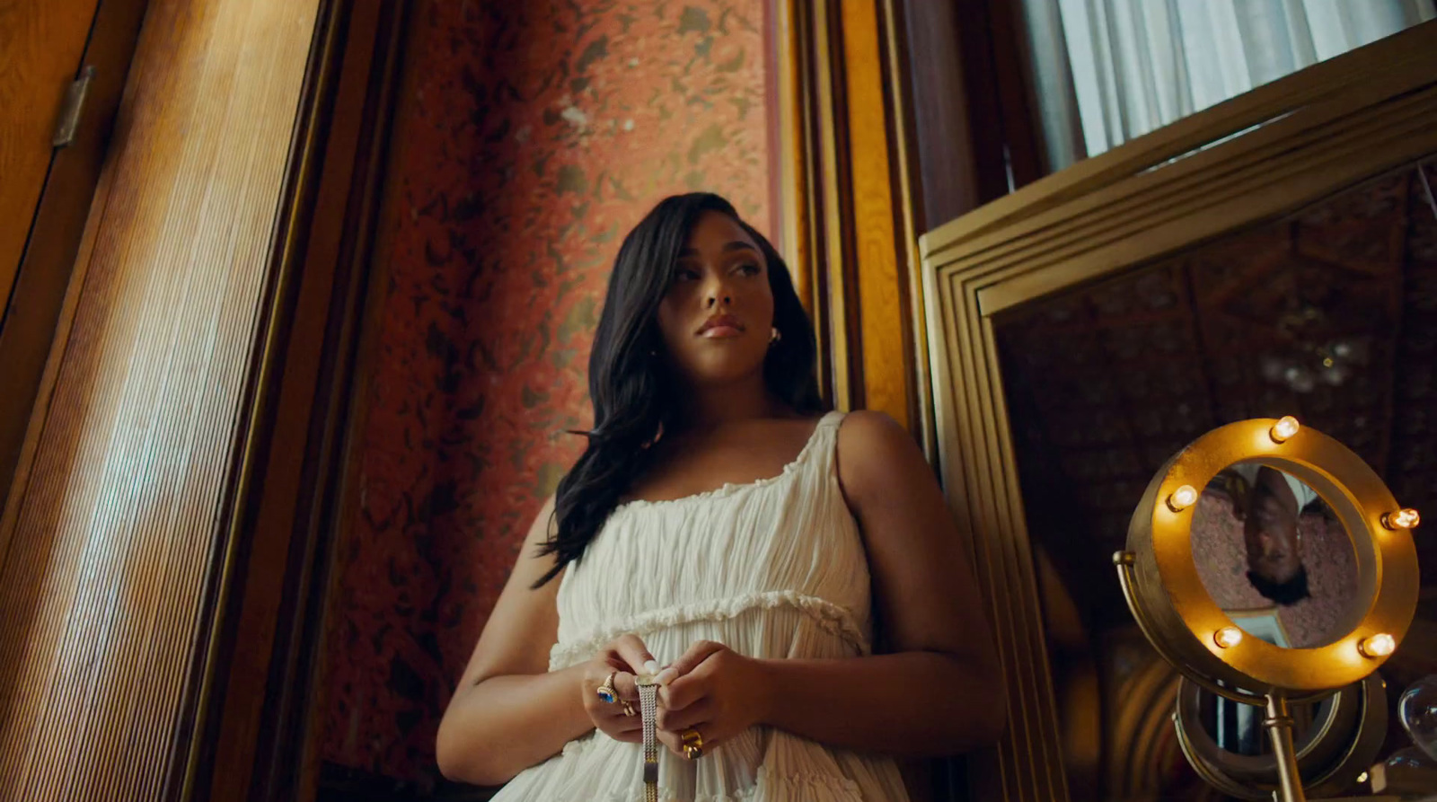 a woman in a white dress standing in front of a mirror