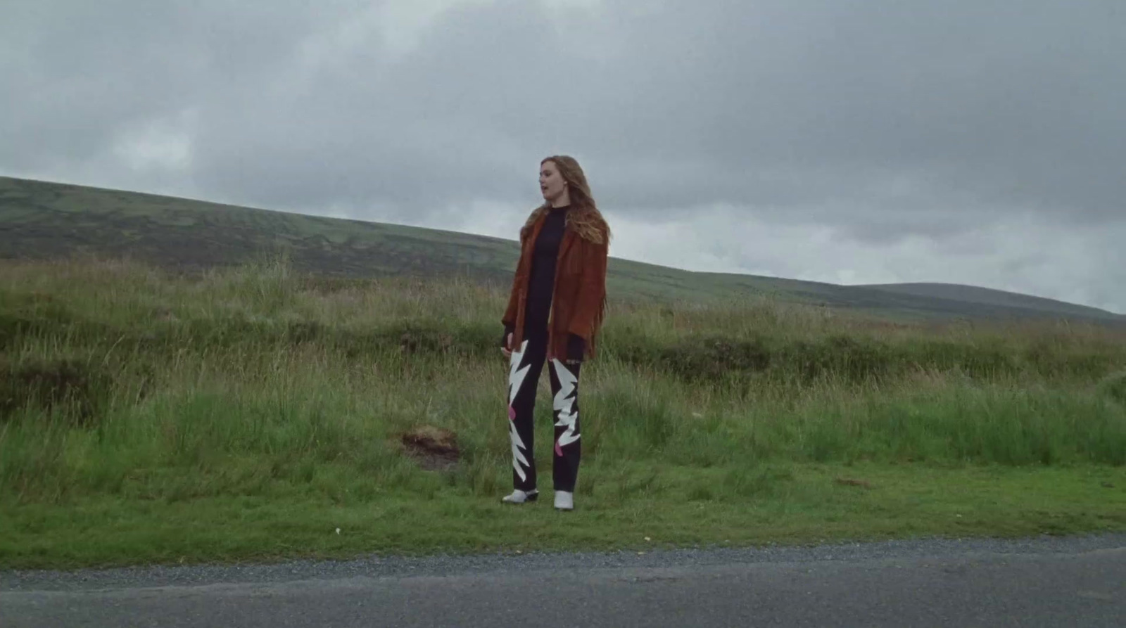 a woman standing on the side of a road