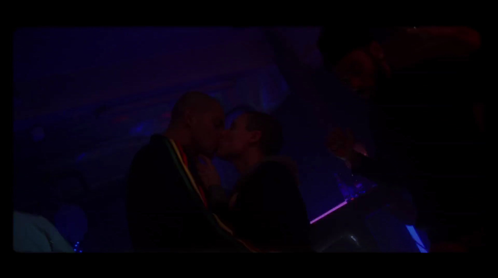 a man and a woman kissing in a dark room