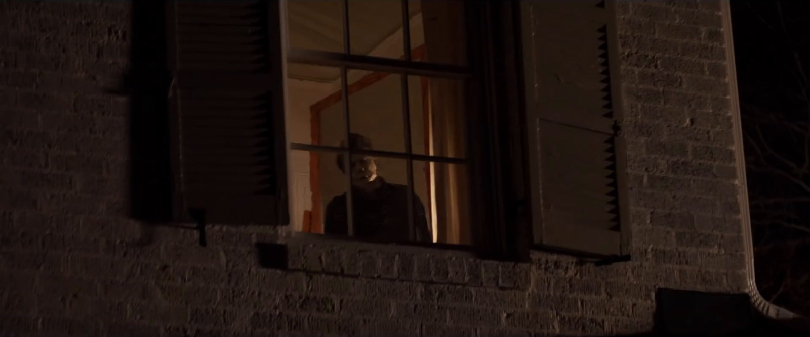 a person looking out of a window at night