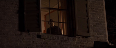 a person looking out of a window at night