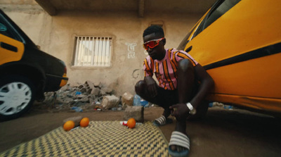 a man kneeling down next to a yellow car