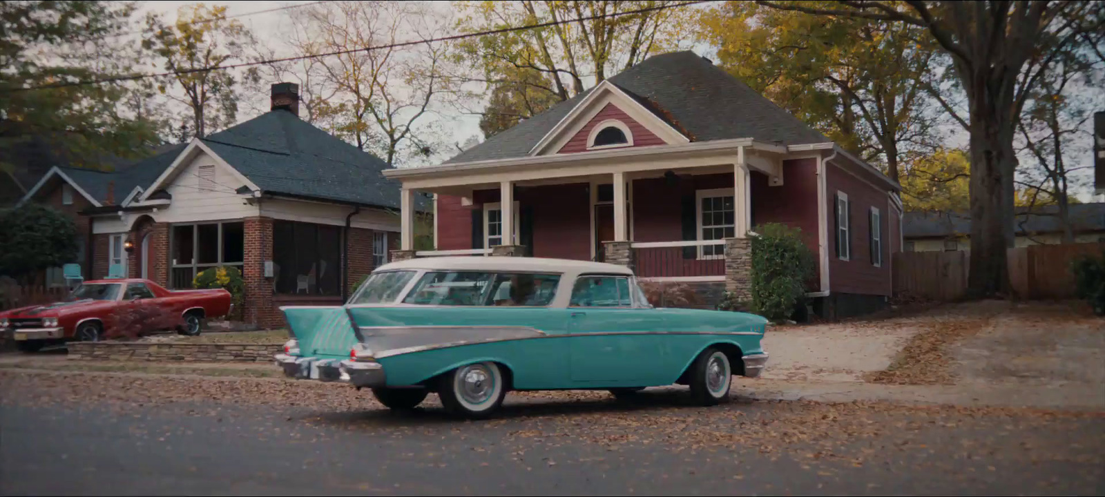 an old car parked in front of a house