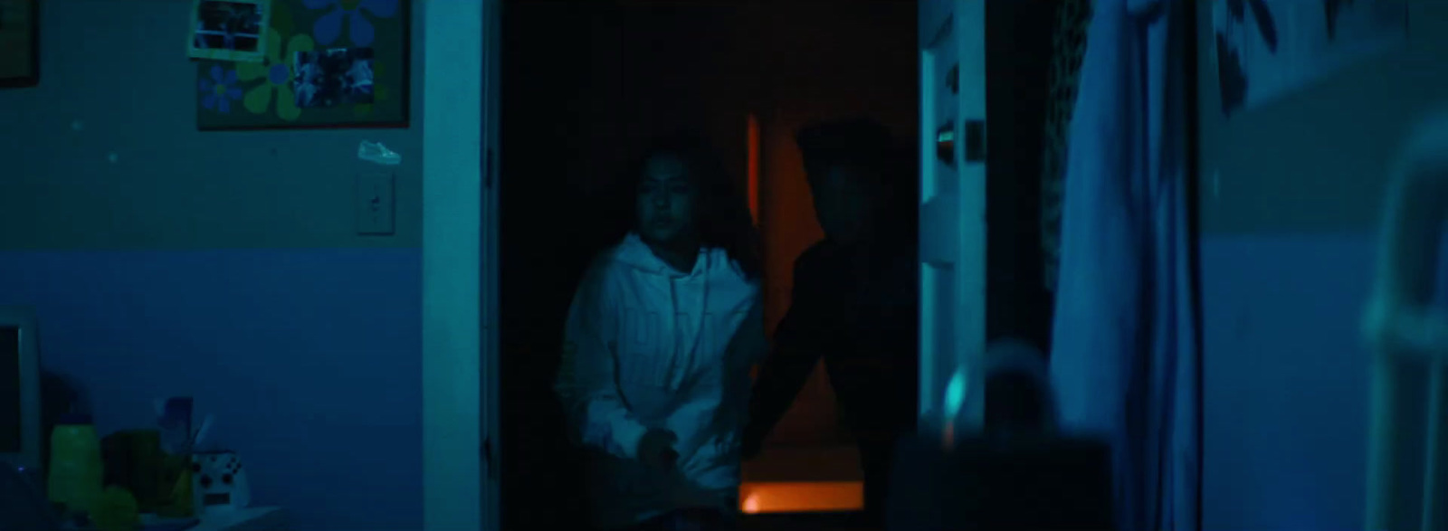 two people standing in a doorway at night