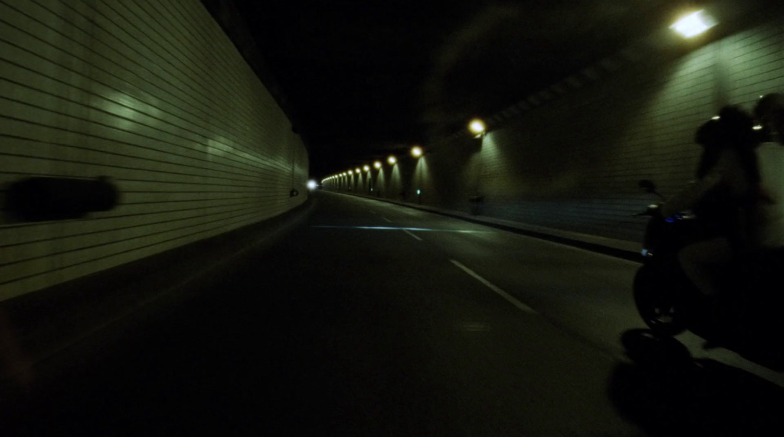 a person riding a scooter in a tunnel