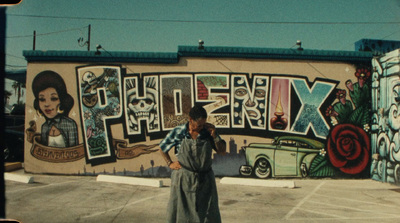 a woman standing in front of a wall with a mural on it