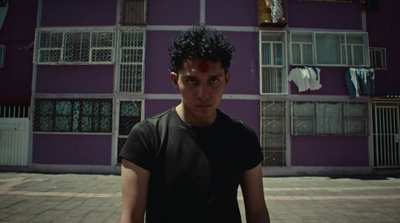 a man standing in front of a purple building