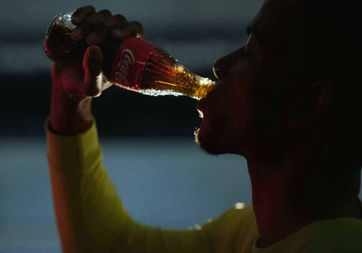 a man drinking a beer from a bottle