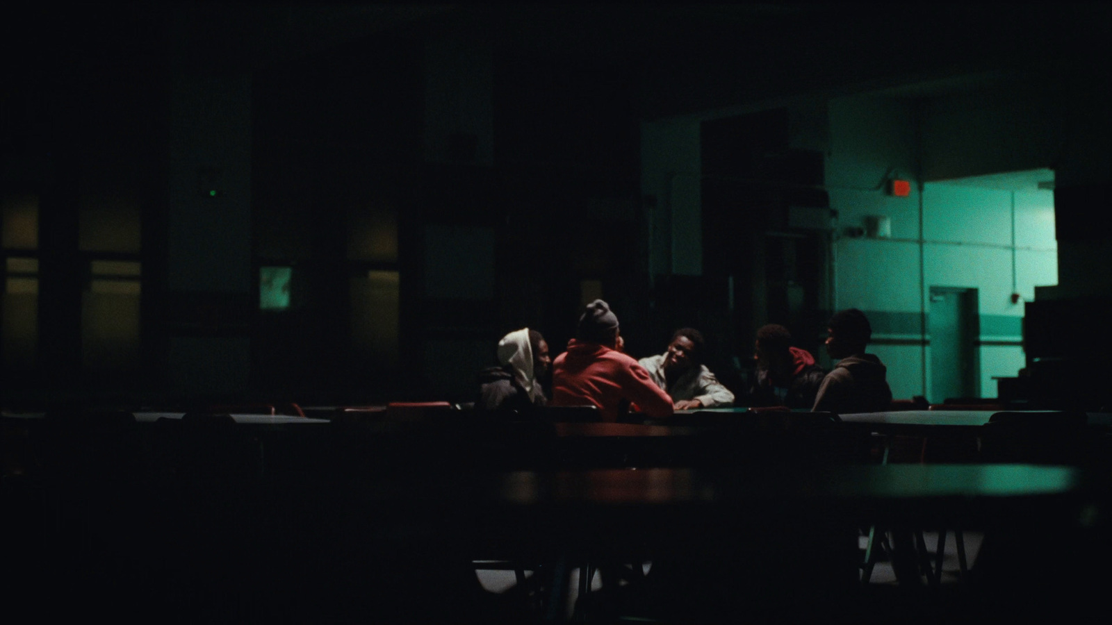 a group of people sitting at a table in a dark room