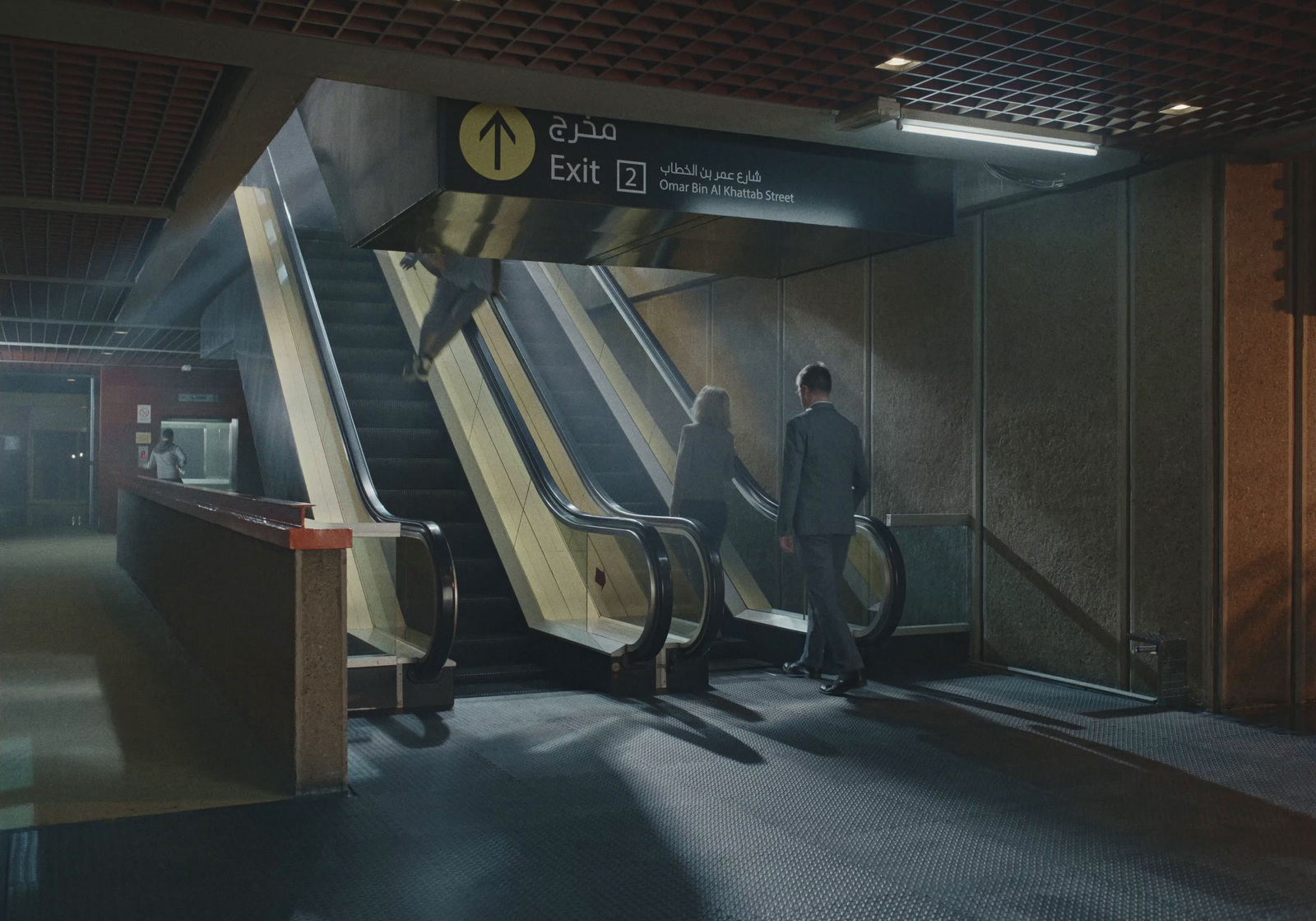 a man standing at the bottom of an escalator