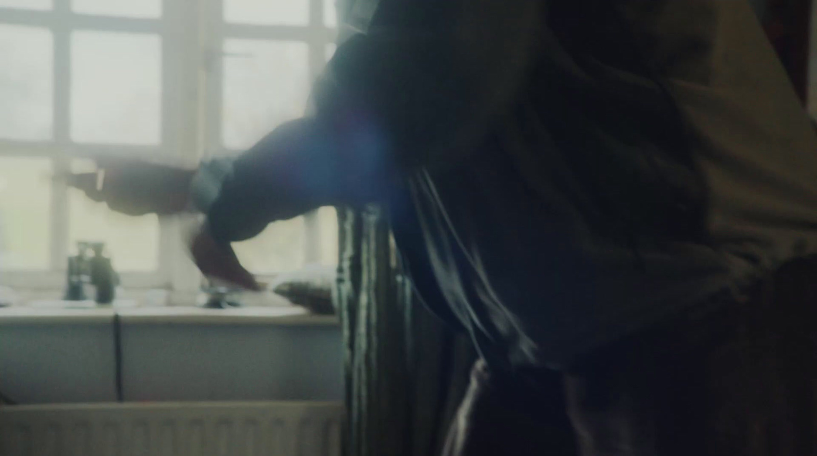 a person standing in a kitchen next to a sink