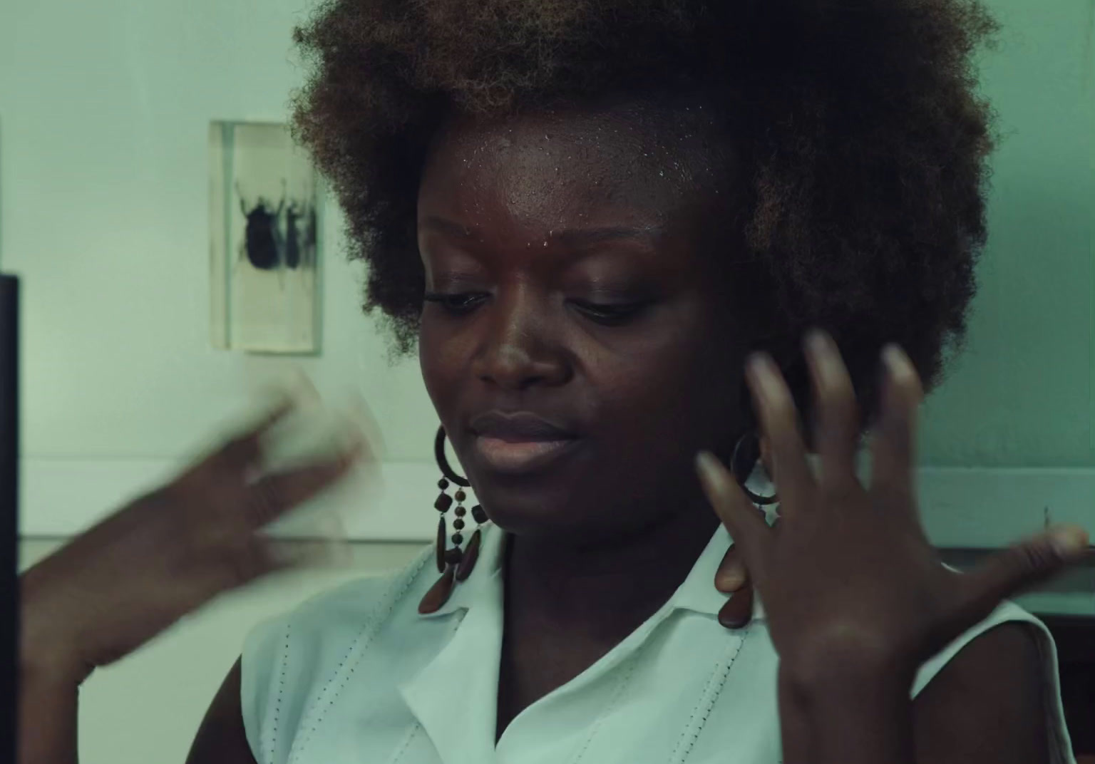 a woman in a white shirt holding her hands up